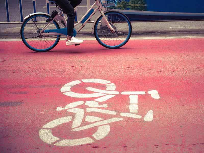 person riding the bicycle on the road coloured in red