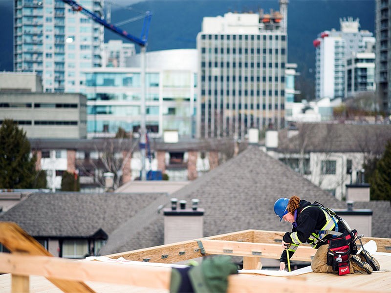 A worker uses a tape measure on one of the top floors of the Adera Development Corp. Crest mass-timber construction site in North Vancouver, British Columbia, Canada, on Tuesday, Feb. 11, 2020. Across Canada, there are plans to build more wood highrises, as the federal building code is set to allow wooden buildings of up to 12 stories, when it's revised later this year, CBC reports. Photographer: James MacDonald/Bloomberg via Getty Images