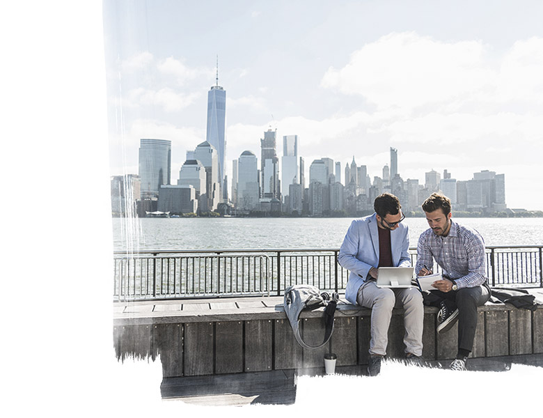 Two colleagues working at New Jersey waterfront with view to Manhattan