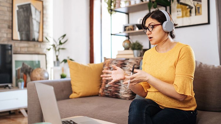 Woman working remotely from home and having a conversation with her colleague in a virtual meeting