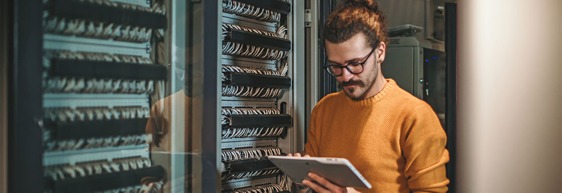 Man working on a tablet in a data center